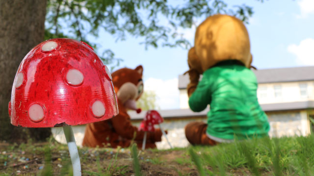 Guests enjoy playful garden with colourful toadstool sculptures and character mascots, perfect for family fun and relaxation.