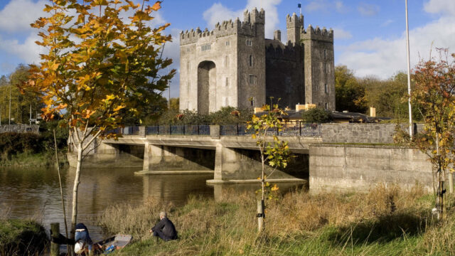 Enjoy serene riverside views of a historic castle with autumn foliage, perfect for a peaceful getaway near nature and history.