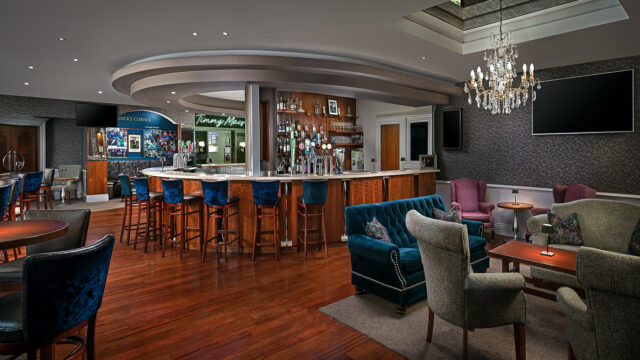 Elegant hotel bar with plush seating, chandeliers, and a modern counter serving drinks, perfect for relaxing evenings.