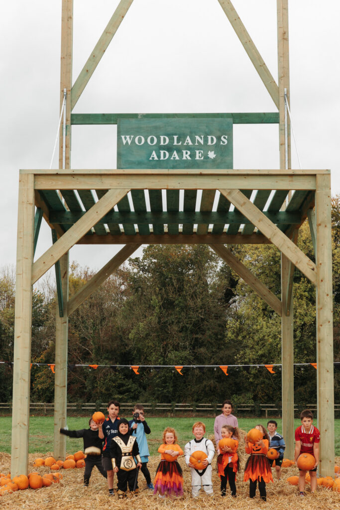 Kids enjoy pumpkin picking at Woodlands Adare, surrounded by autumn scenery, perfect for family-friendly activities.