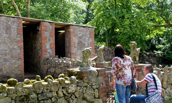Guests exploring the charming stone ruins and lush greenery within the hotel's serene garden, perfect for a peaceful retreat.