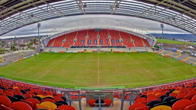 Vibrant stadium with colourful seating, lush green field, and expansive views; ideal for sports enthusiasts staying at nearby hotels.