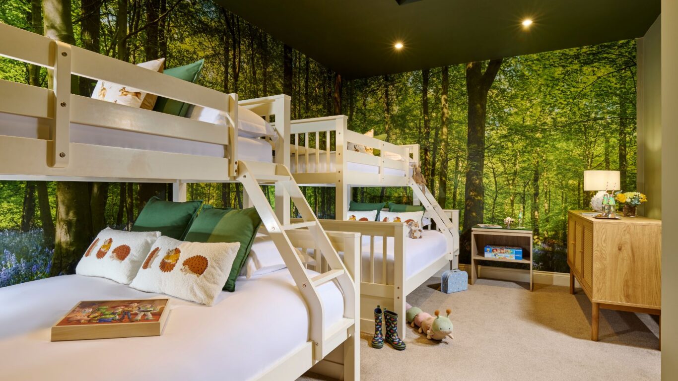 Cosy children's hotel room with forest wallpaper, bunk beds, playful toys, and inviting atmosphere for a delightful stay.